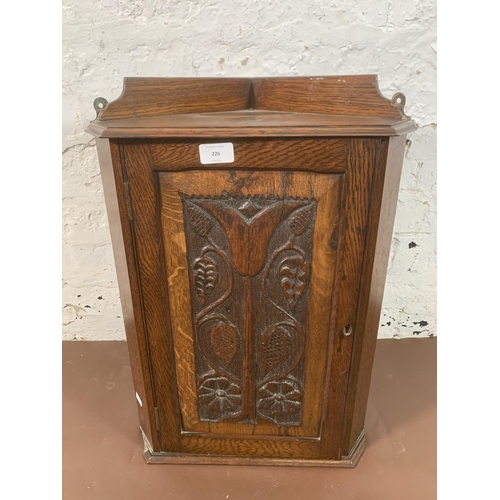 226 - An Arts & Crafts carved oak wall mountable corner cabinet - approx. 56cm high x 41cm wide x 27cm dee... 