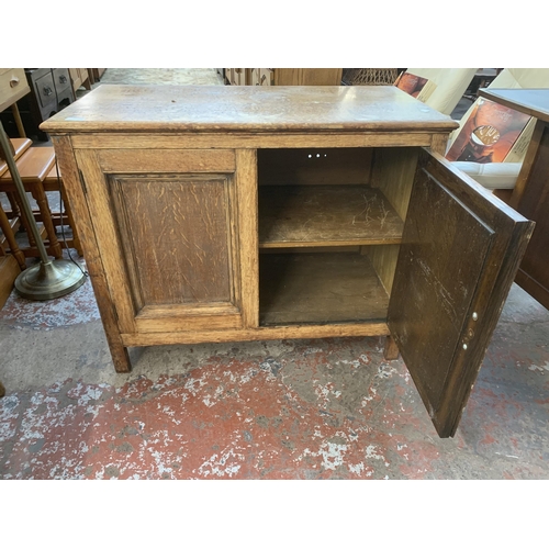 227 - A 1930s oak two door cabinet - approx. 77cm high x 93cm wide x 45cm deep