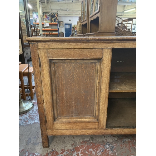 227 - A 1930s oak two door cabinet - approx. 77cm high x 93cm wide x 45cm deep