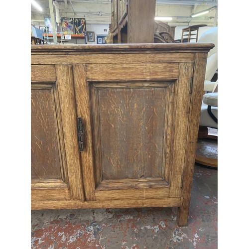 227 - A 1930s oak two door cabinet - approx. 77cm high x 93cm wide x 45cm deep