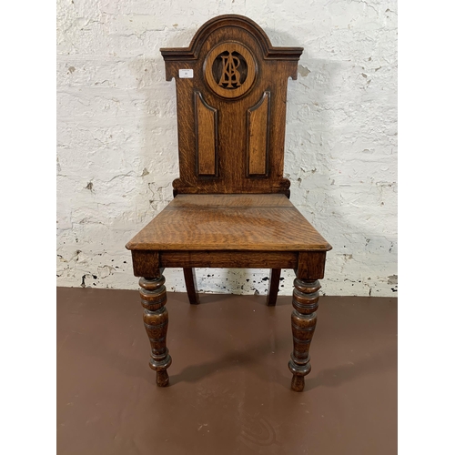 23 - A 19th century carved oak hall chair - approx. 89cm high x 43cm wide x 37cm deep