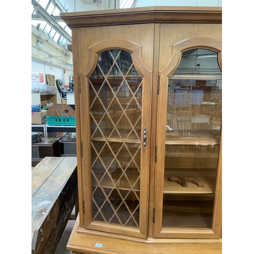 244 - A large 20th century teak display cabinet with carved floral motives - approx. 200cm high x 180cm wi... 