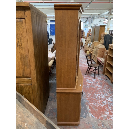 244 - A large 20th century teak display cabinet with carved floral motives - approx. 200cm high x 180cm wi... 