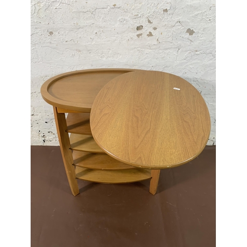 248 - A beech oval swivel top five tier side table - approx. 62cm high x 94cm wide x 38cm deep