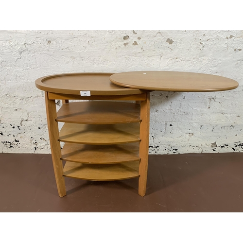 248 - A beech oval swivel top five tier side table - approx. 62cm high x 94cm wide x 38cm deep