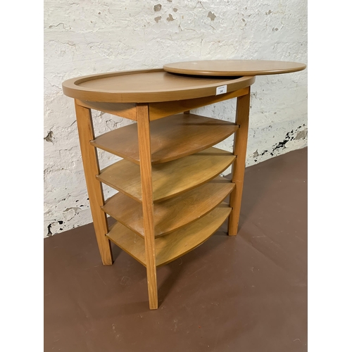 248 - A beech oval swivel top five tier side table - approx. 62cm high x 94cm wide x 38cm deep