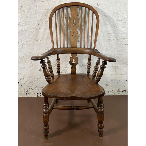 253 - A 19th century elm and beech Windsor chair with carved splat back -approx. 114cm high x 66cm wide x ... 