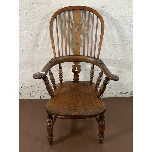 253 - A 19th century elm and beech Windsor chair with carved splat back -approx. 114cm high x 66cm wide x ... 