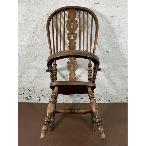 253 - A 19th century elm and beech Windsor chair with carved splat back -approx. 114cm high x 66cm wide x ... 