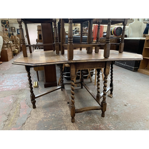 260 - An early 20th century oak drop leaf gate leg dining table on barley twist supports and four oak ladd... 