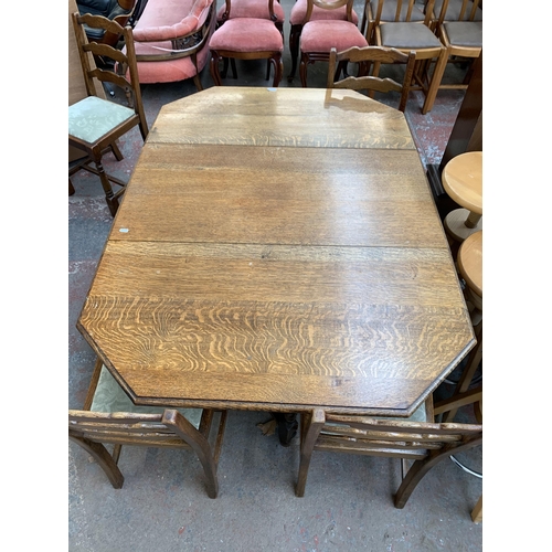 260 - An early 20th century oak drop leaf gate leg dining table on barley twist supports and four oak ladd... 