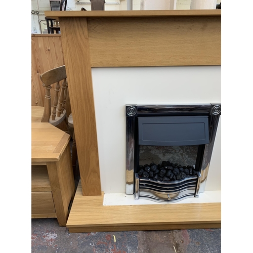 300A - A modern oak fire surround with electric fire - approx. 112cm high x 120cm wide x 38cm deep