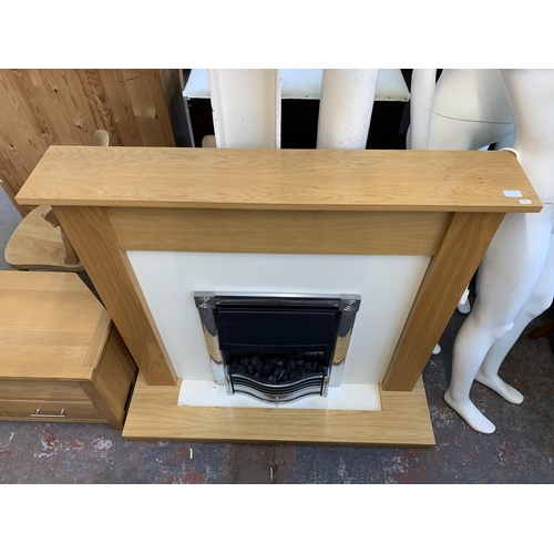 300A - A modern oak fire surround with electric fire - approx. 112cm high x 120cm wide x 38cm deep