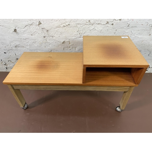 47 - A mid 20th century beech and teak effect telephone table on castors - approx. 42cm high x 70cm wide ... 