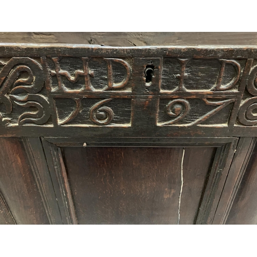 62 - A 17th century and later carved oak coffer with inscription to front and two plank top - approx. 68c... 