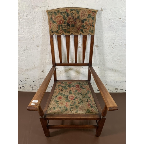 63 - An Arts & Crafts mahogany and floral fabric upholstered armchair - approx. 110cm high x 59cm wide x ... 