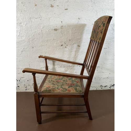 63 - An Arts & Crafts mahogany and floral fabric upholstered armchair - approx. 110cm high x 59cm wide x ... 