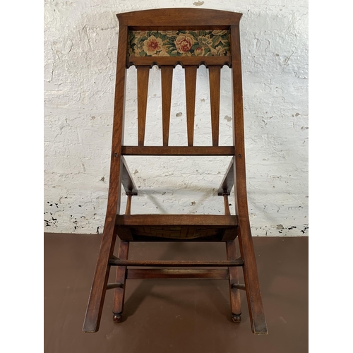 63 - An Arts & Crafts mahogany and floral fabric upholstered armchair - approx. 110cm high x 59cm wide x ... 