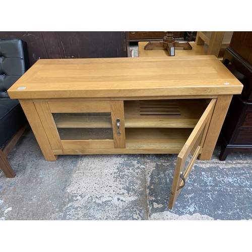 90 - A modern oak two door TV stand - approx. 60cm high x 105cm wide x 46cm deep