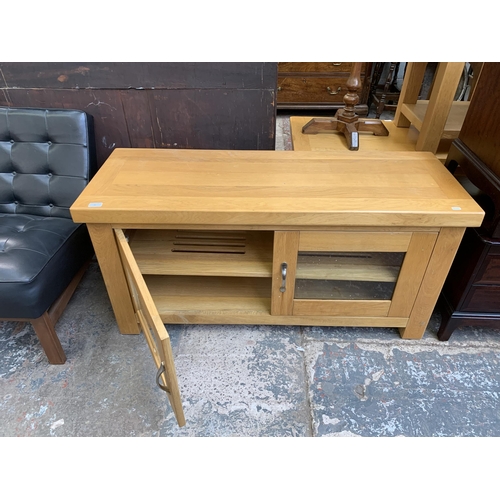 90 - A modern oak two door TV stand - approx. 60cm high x 105cm wide x 46cm deep