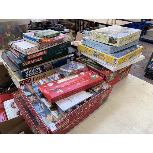 493 - A collection of boxed puzzles and board games to include Scrabble, Monopoly, 1000 piece Little Moret... 