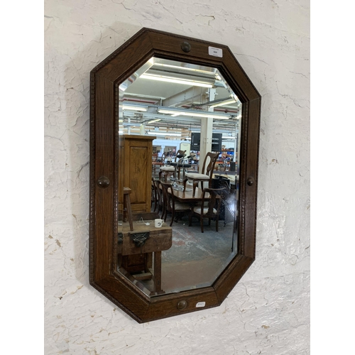 664 - An early 20th century oak framed octagon bevelled edge wall mirror - approx. 67cm x 44cm