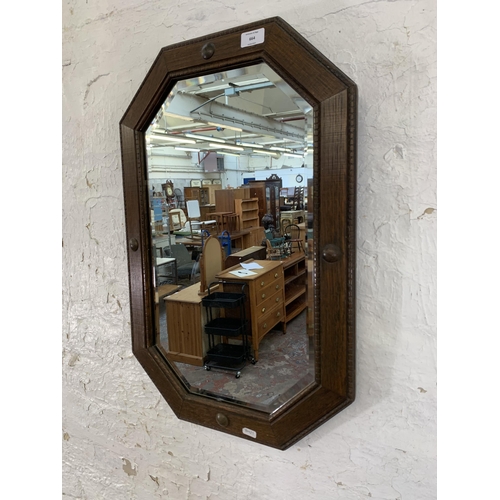 664 - An early 20th century oak framed octagon bevelled edge wall mirror - approx. 67cm x 44cm