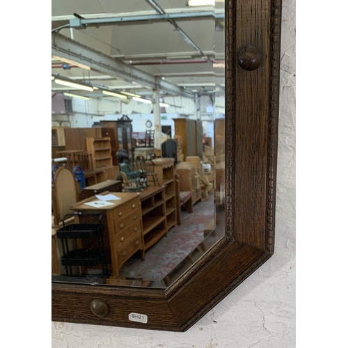 664 - An early 20th century oak framed octagon bevelled edge wall mirror - approx. 67cm x 44cm