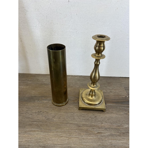 431 - Six pieces of brassware, four candlesticks - largest approx. 40cm high, one WWII shell case - approx... 