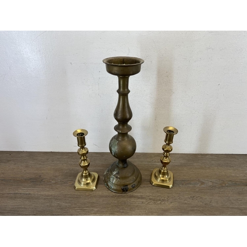 431 - Six pieces of brassware, four candlesticks - largest approx. 40cm high, one WWII shell case - approx... 