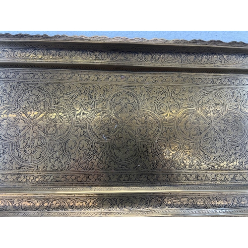 442 - Two antique brass serving trays, one engraved and one embossed