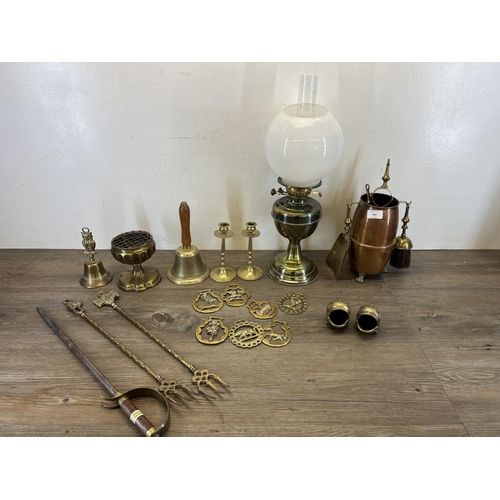 469 - A collection of vintage copper and brassware to include candlesticks, horse brasses, bells, fish orn... 