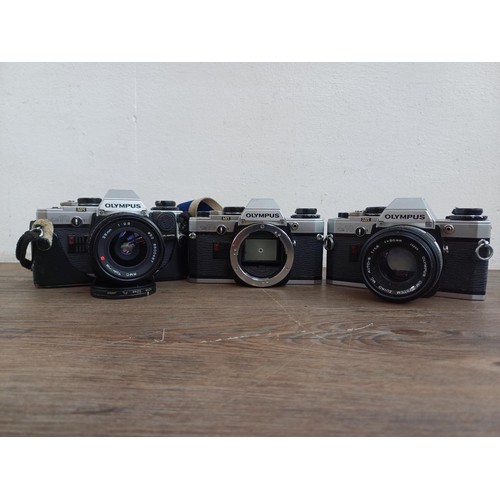 694 - Three Olympus OM10 354mm SLR cameras, one fitted with Zuiko MC 1:1.8 f=50mm lens, one body only and ... 