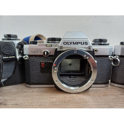 694 - Three Olympus OM10 354mm SLR cameras, one fitted with Zuiko MC 1:1.8 f=50mm lens, one body only and ... 