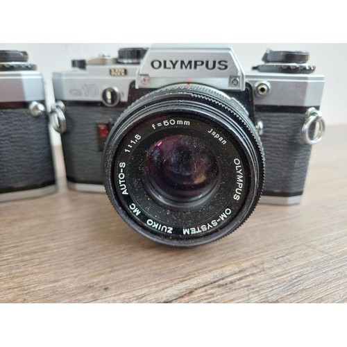 694 - Three Olympus OM10 354mm SLR cameras, one fitted with Zuiko MC 1:1.8 f=50mm lens, one body only and ... 