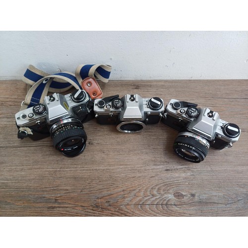 694 - Three Olympus OM10 354mm SLR cameras, one fitted with Zuiko MC 1:1.8 f=50mm lens, one body only and ... 