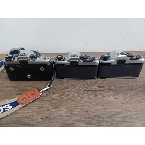 694 - Three Olympus OM10 354mm SLR cameras, one fitted with Zuiko MC 1:1.8 f=50mm lens, one body only and ... 