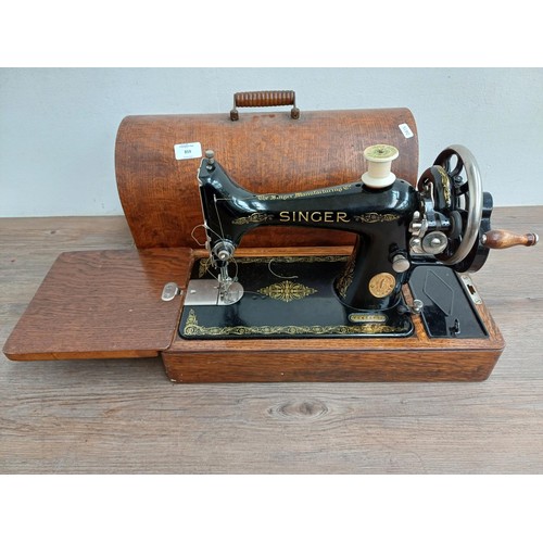 859 - A cased 1932 Singer 99K hand crank sewing machine with attachments and instruction manual