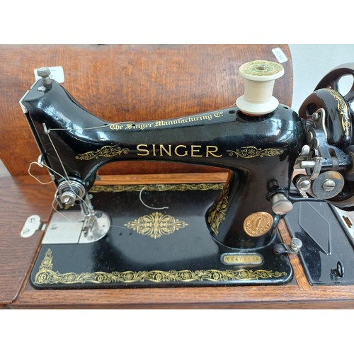 859 - A cased 1932 Singer 99K hand crank sewing machine with attachments and instruction manual