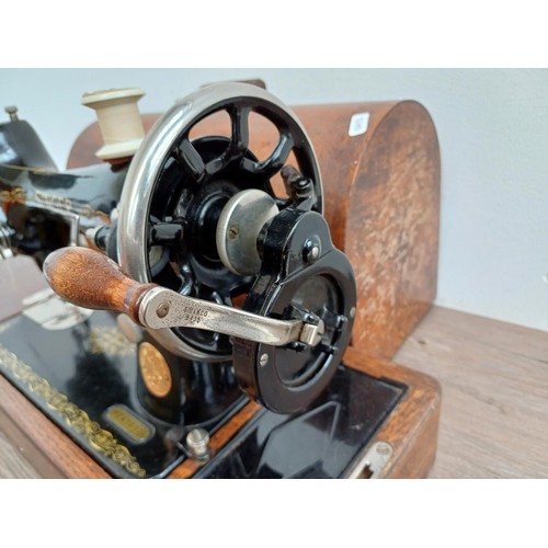 859 - A cased 1932 Singer 99K hand crank sewing machine with attachments and instruction manual