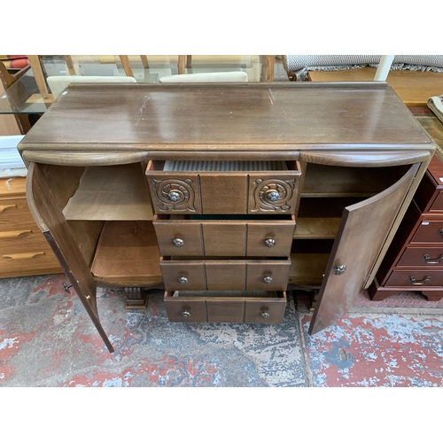 101 - A mid 20th century Art Deco style carved oak sideboard