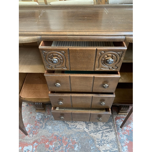 101 - A mid 20th century Art Deco style carved oak sideboard