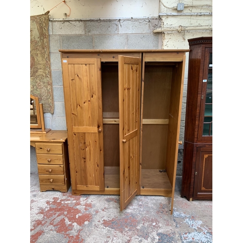 25 - A modern pine triple wardrobe - approx. 183cm high x 139cm wide x 53cm deep