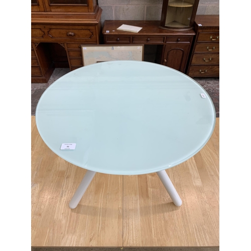 51 - A modern glass top and white metal tripod side table - approx. 50cm high x 60cm diameter