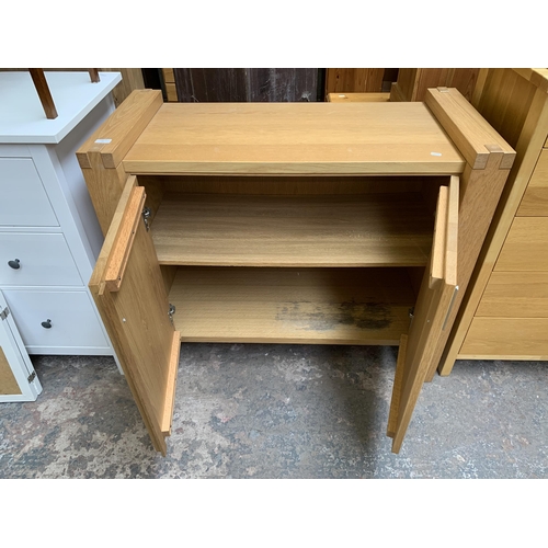 65 - A modern oak two door sideboard - approx. 90cm high x 105cm wide x 49cm deep