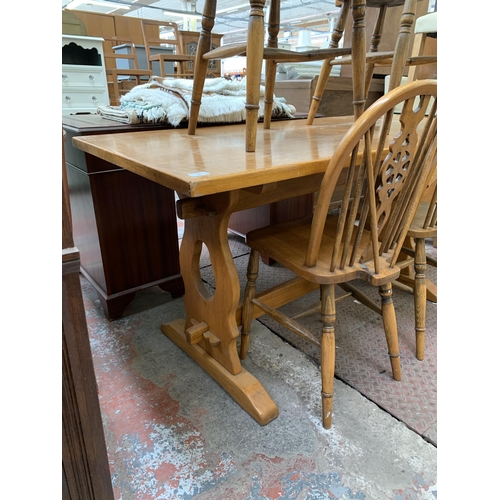 78 - A mid 20th century oak rectangular trestle dining table and four wheel back chairs - table approx. 7... 