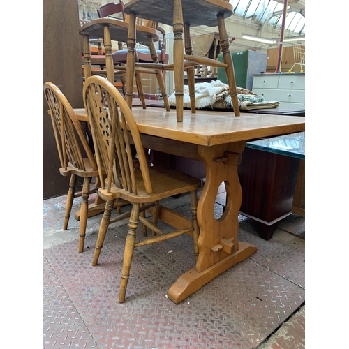 78 - A mid 20th century oak rectangular trestle dining table and four wheel back chairs - table approx. 7... 