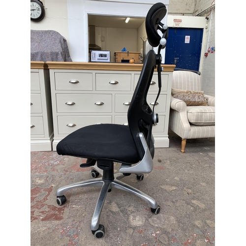 89 - A modern black fabric and meshed office swivel desk chair with adjustable headrest