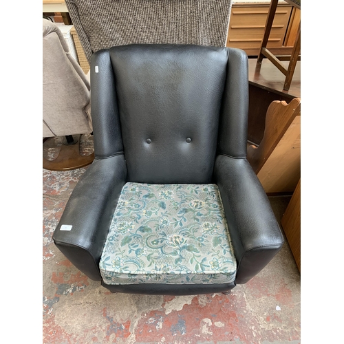 96 - A mid 20th century black vinyl upholstered armchair with floral cushion - approx. 92cm high x 80cm w... 