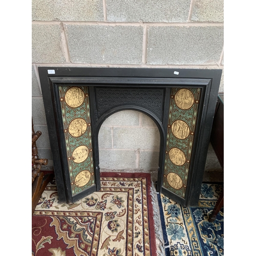 23 - A Victorian cast iron fire surround with ceramic tile inserts - approx. 100cm high x 102cm wide